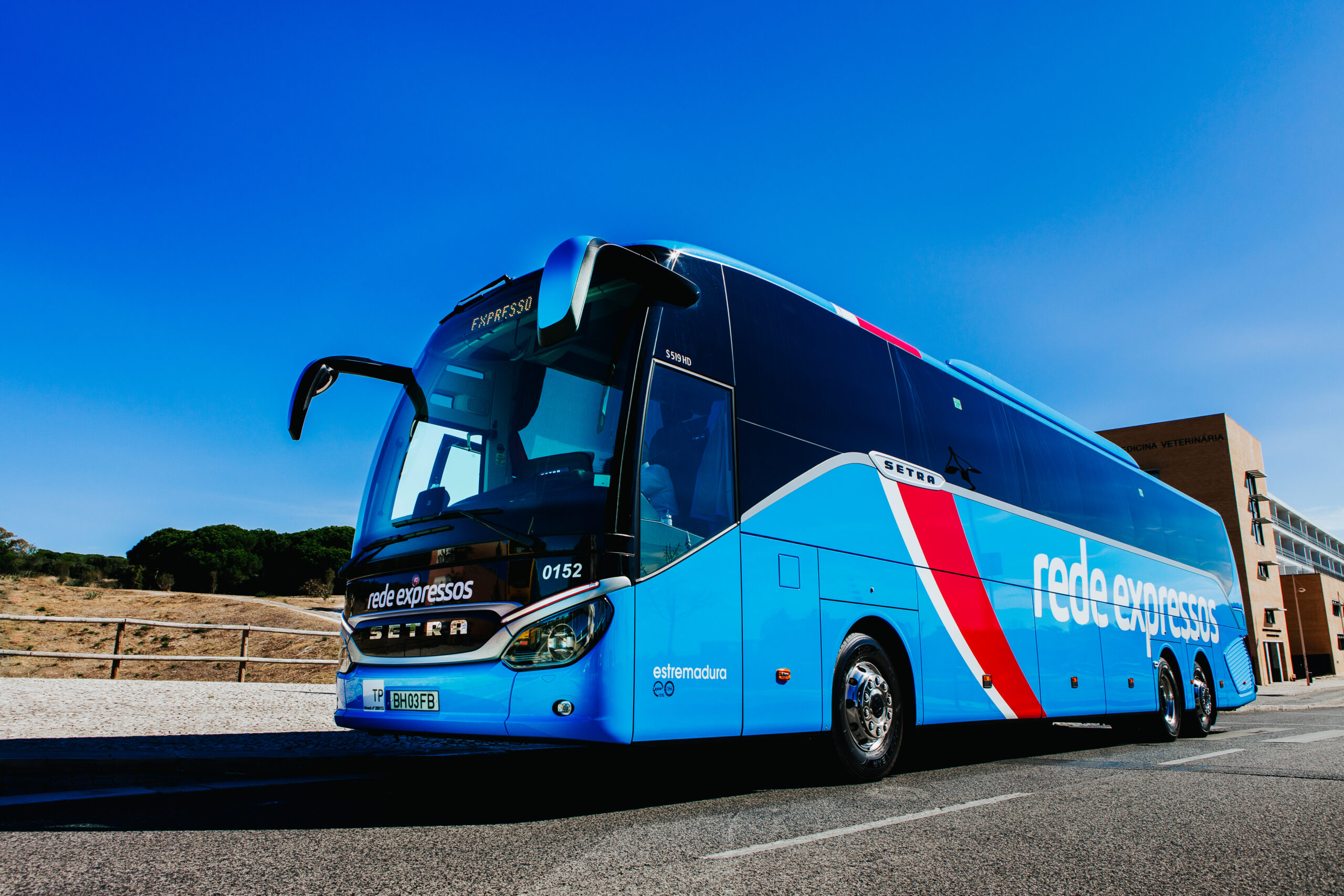 The image illustrates SETRA intercity coach with livery of Rede Nacional de Expressos parked on a roadside on a sunny day